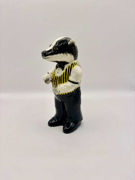 Badger figurine wearing a vest on a white background