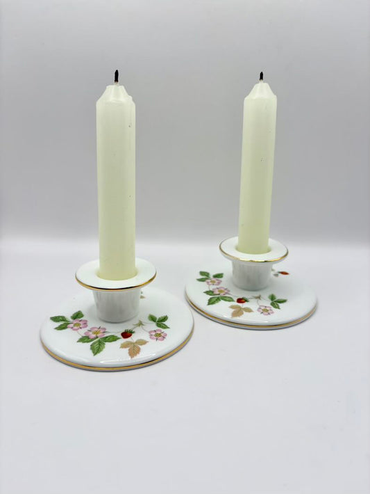 Two candle holders with candles on a white background