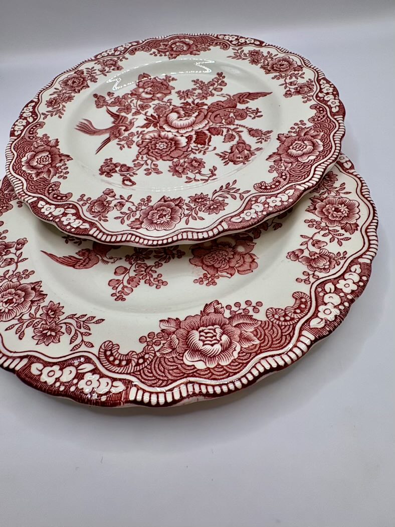 Set of red floral-patterned plates on a white background