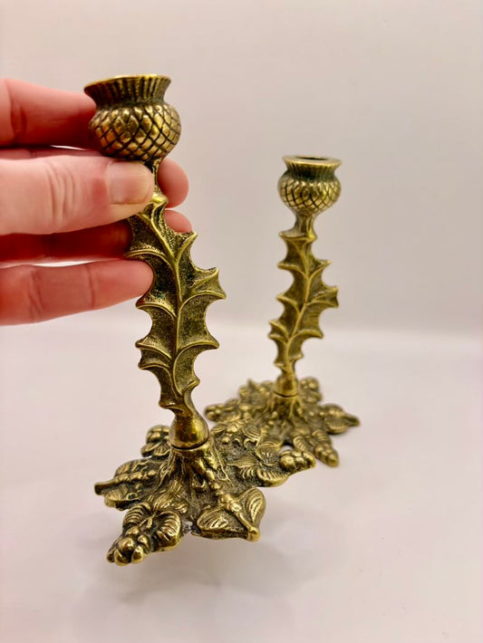 Decorative brass candle holder with intricate designs on a white background