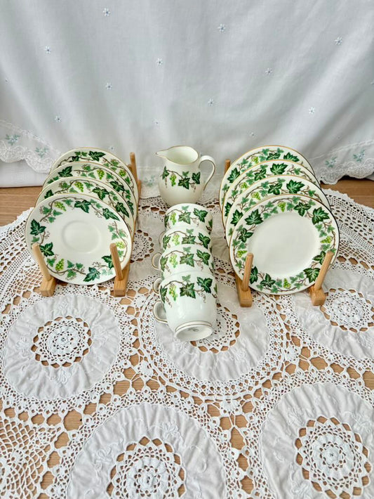 Set of ceramic plates with green leaf pattern on a lace tablecloth