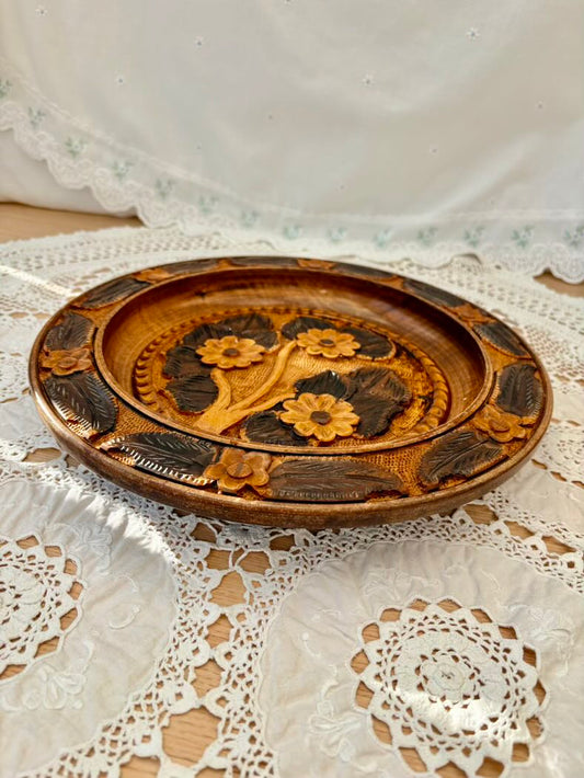 Wooden plate with floral carvings on a lace tablecloth