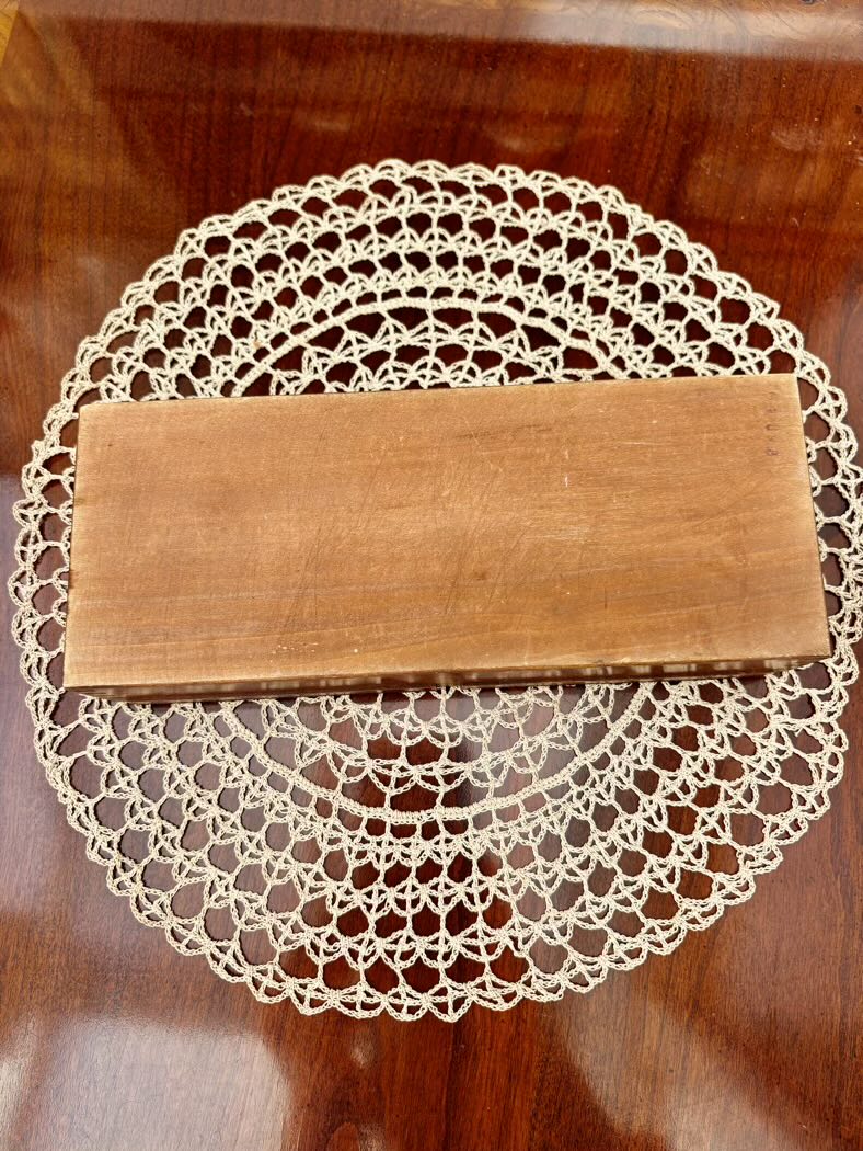 Wooden book on a lace doily on a wooden surface