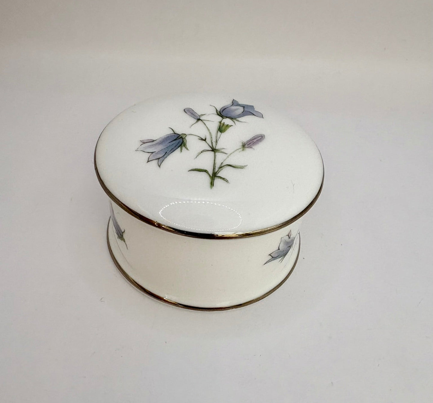 Round vintage porcelain trinket box with floral design and lid