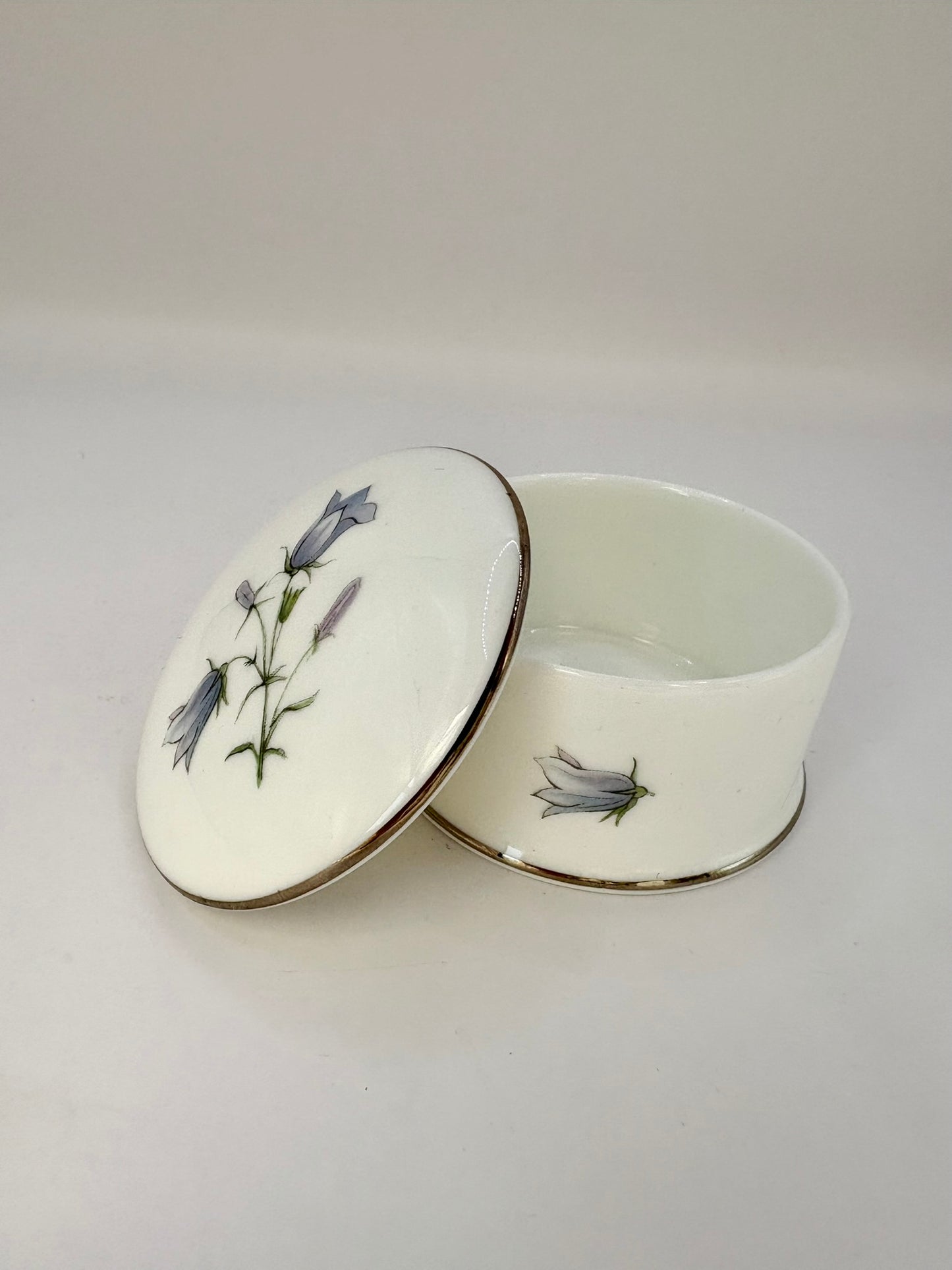 Round vintage porcelain trinket box with floral design and lid