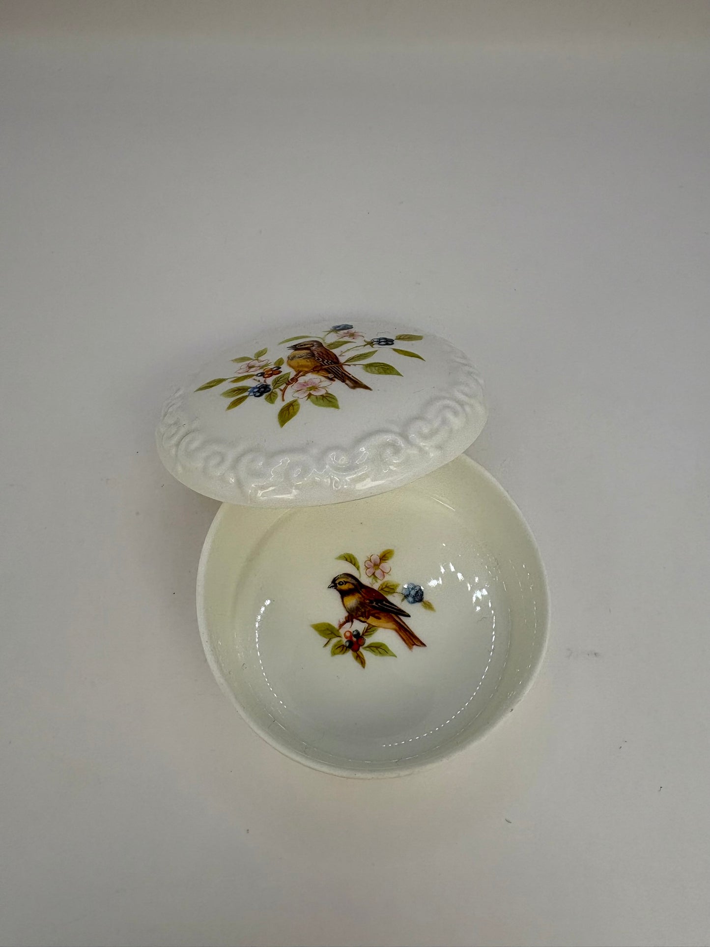 Porcelain trinket box with vintage bird design on lid, perfect for keepsakes
