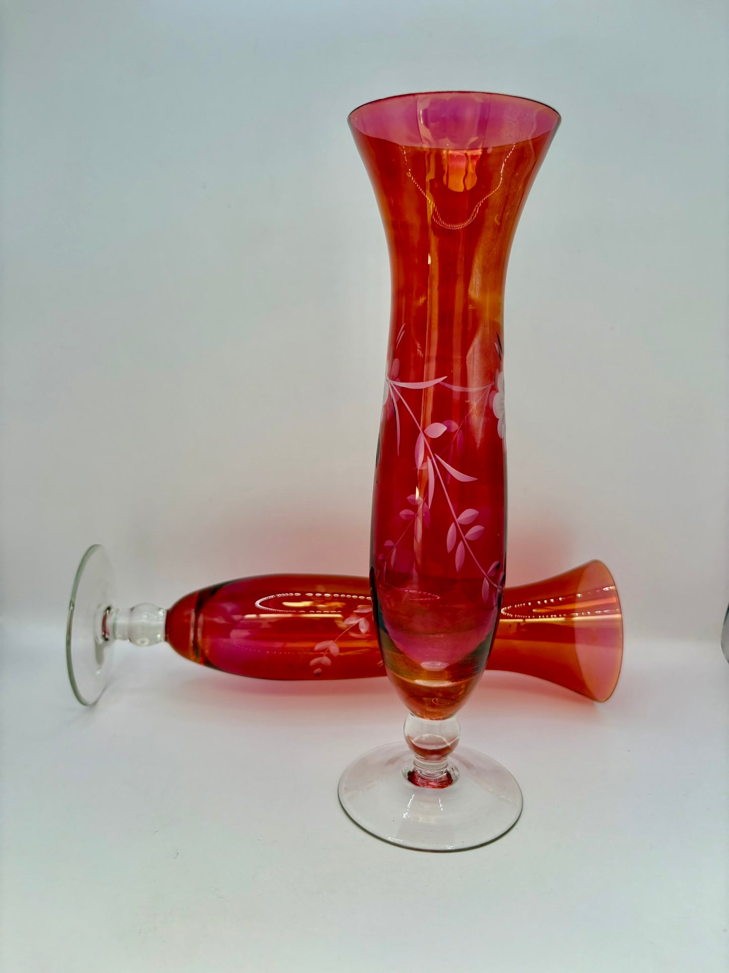 Red glass vase with engraved design on a white background