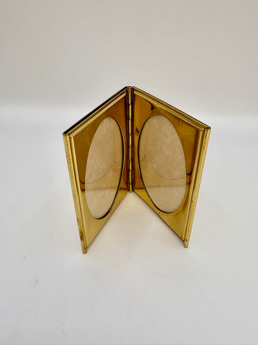 Gold compact mirror with two oval lenses on a white background