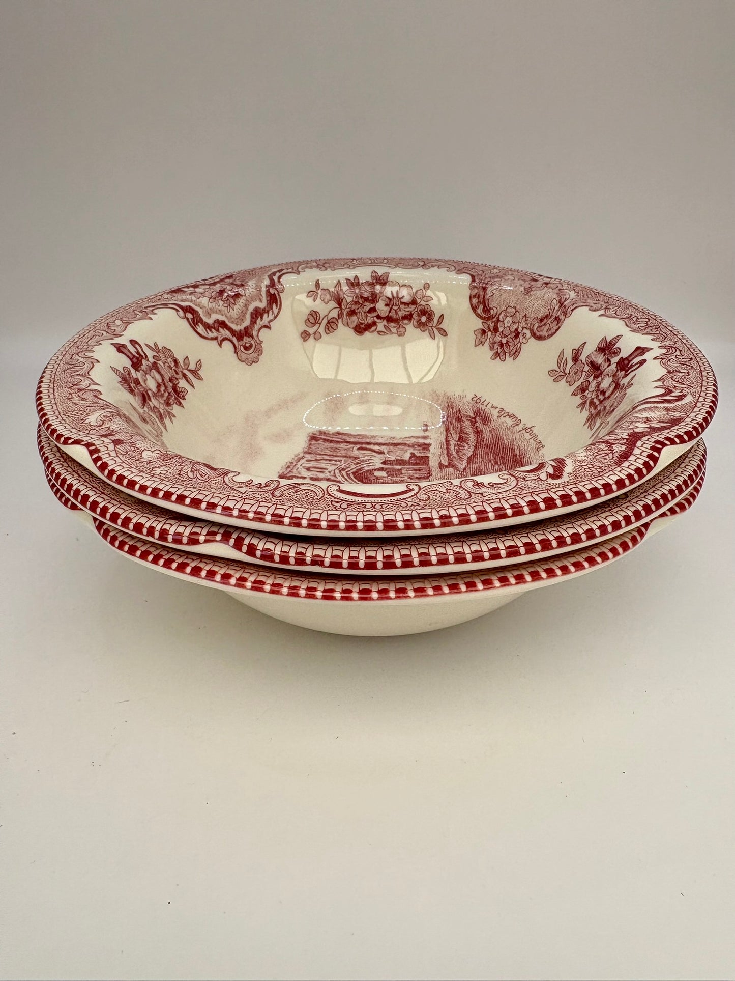 Set of three red and white patterned bowls on a light gray background