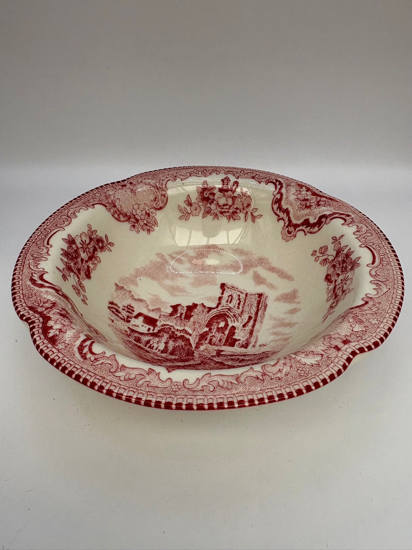 Decorative ceramic bowl with red and white pattern on a white background