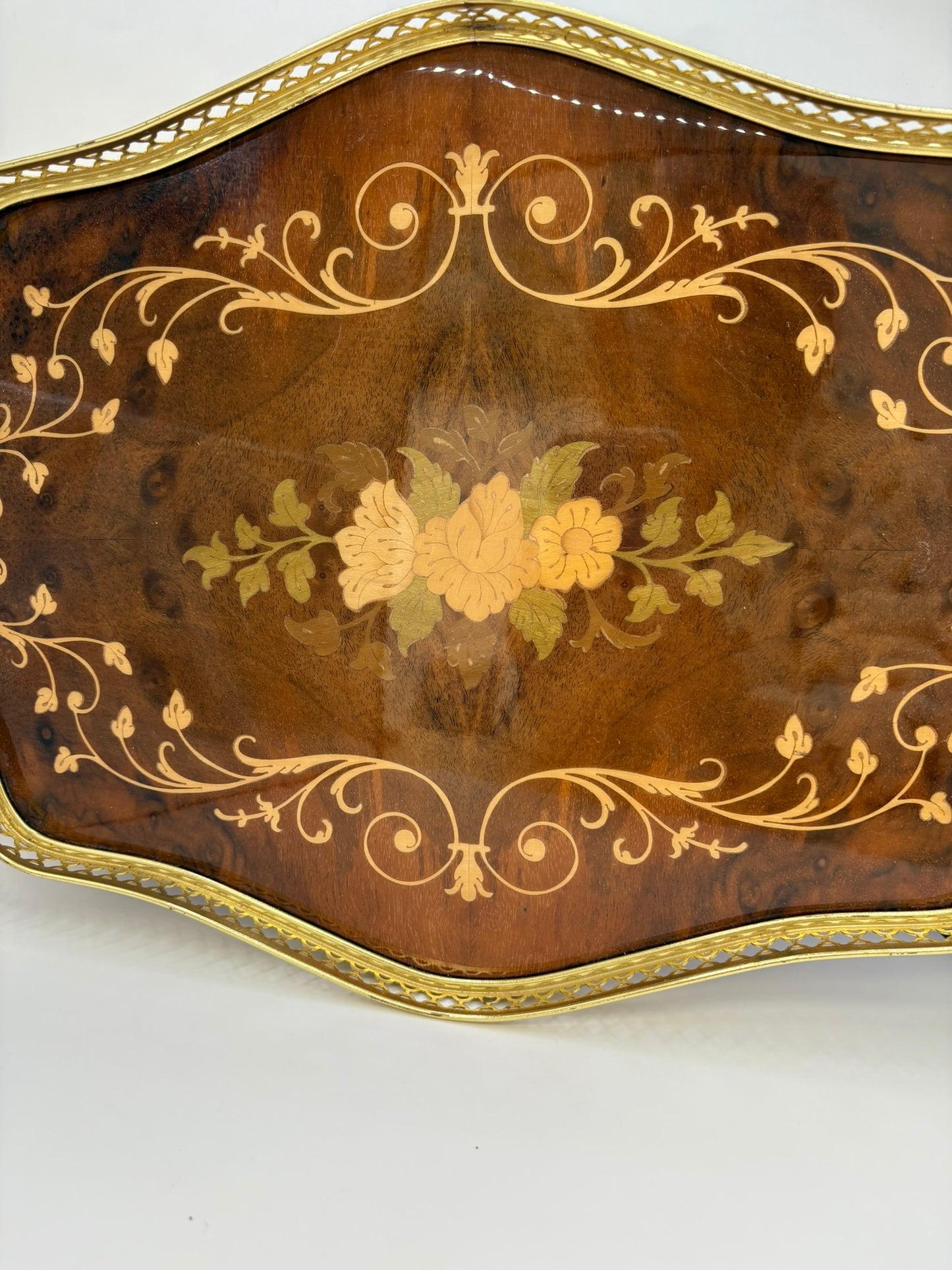 Decorative wooden tray with floral patterns and gold accents on a white background