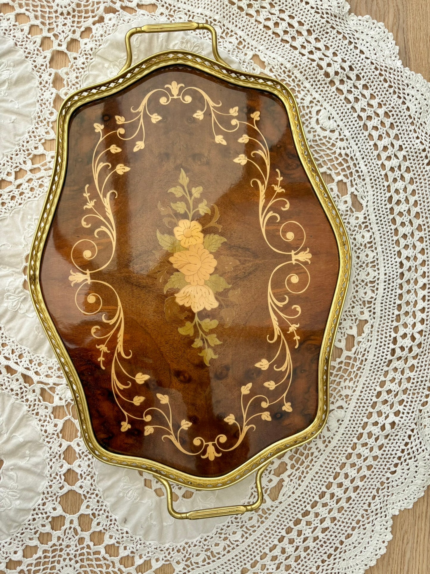 Decorative wooden tray with gold leaf design on a lace tablecloth
