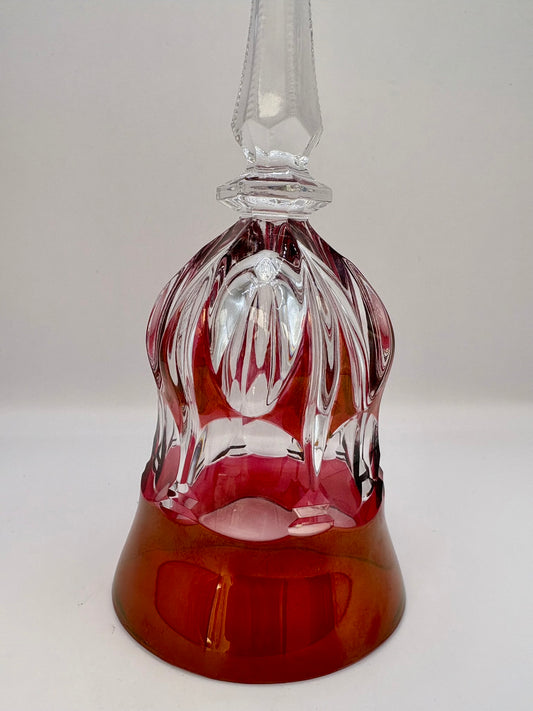 Decorative glass bell with red base and clear top on a white background