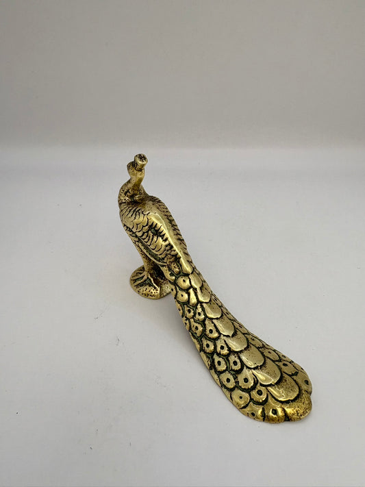 Bronze peacock figure on a white background