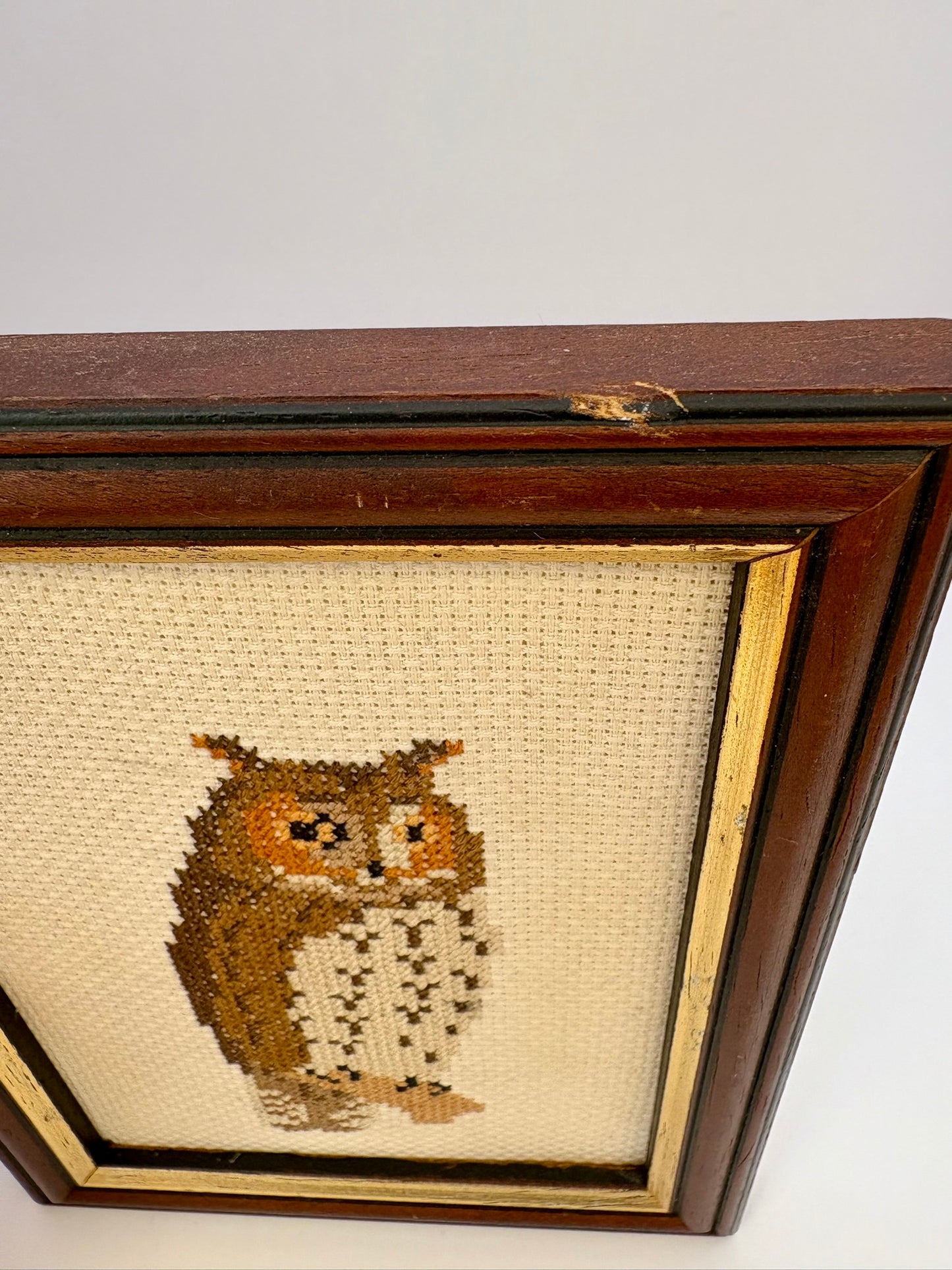 Cross-stitched owl on fabric in a wooden frame