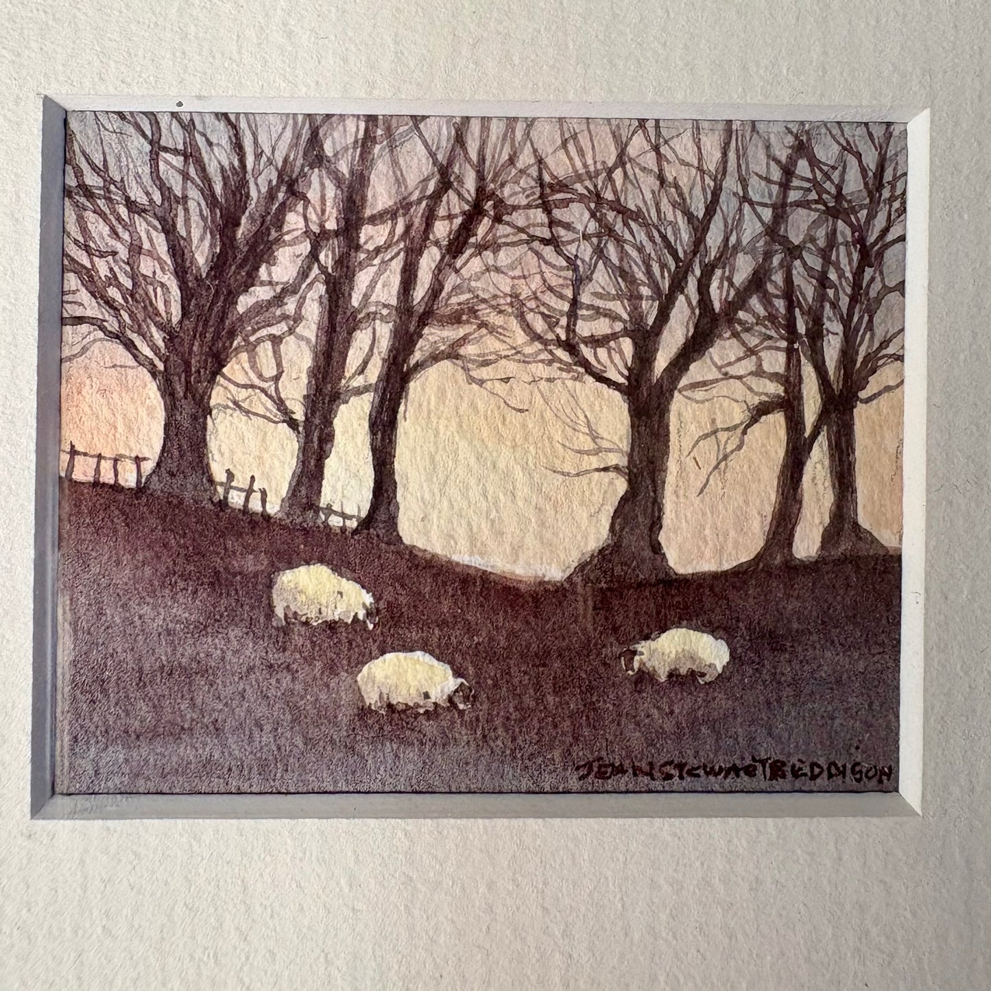 Framed artwork of sheep in a field with trees and a sunset.