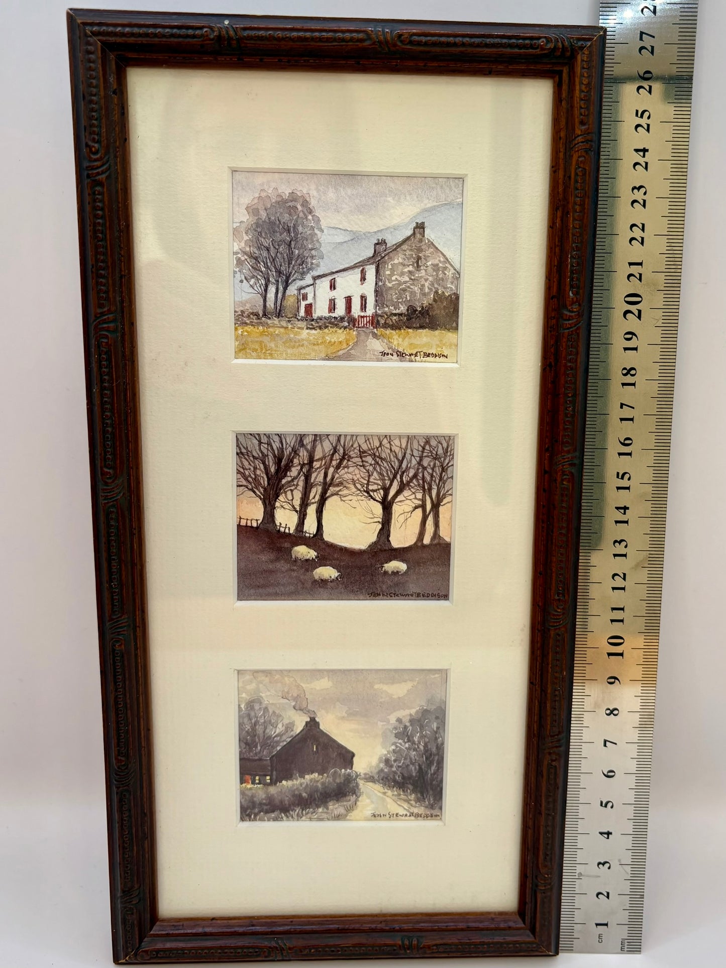 Framed set of four landscape prints with a ruler for scale on a white background