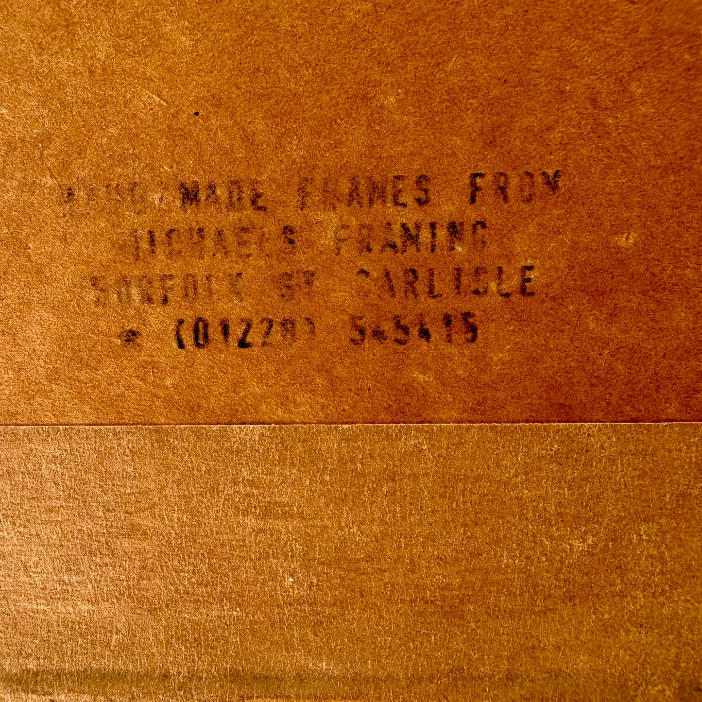 Text on a brown leather surface, likely indicating a brand or product name.