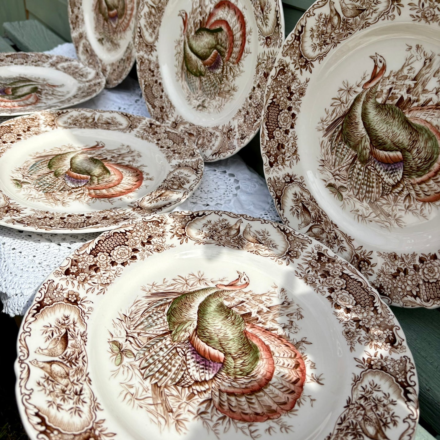 Set of decorative plates with turkey designs on a table.