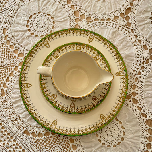 Ceramic dish with green decorative rim on a lace tablecloth