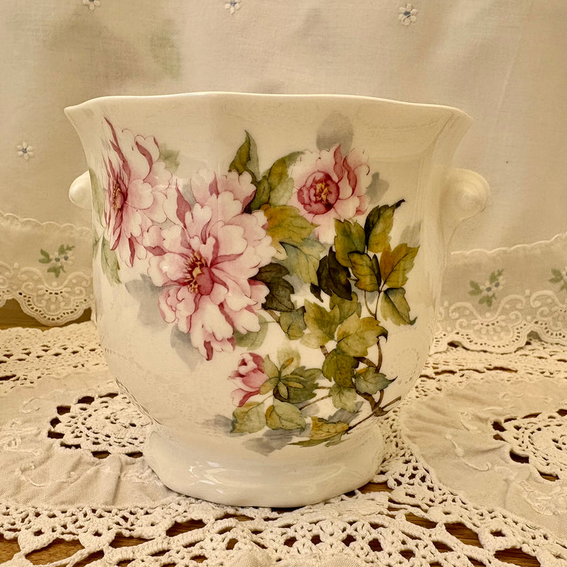 Decorative ceramic vase with floral design on a lace tablecloth