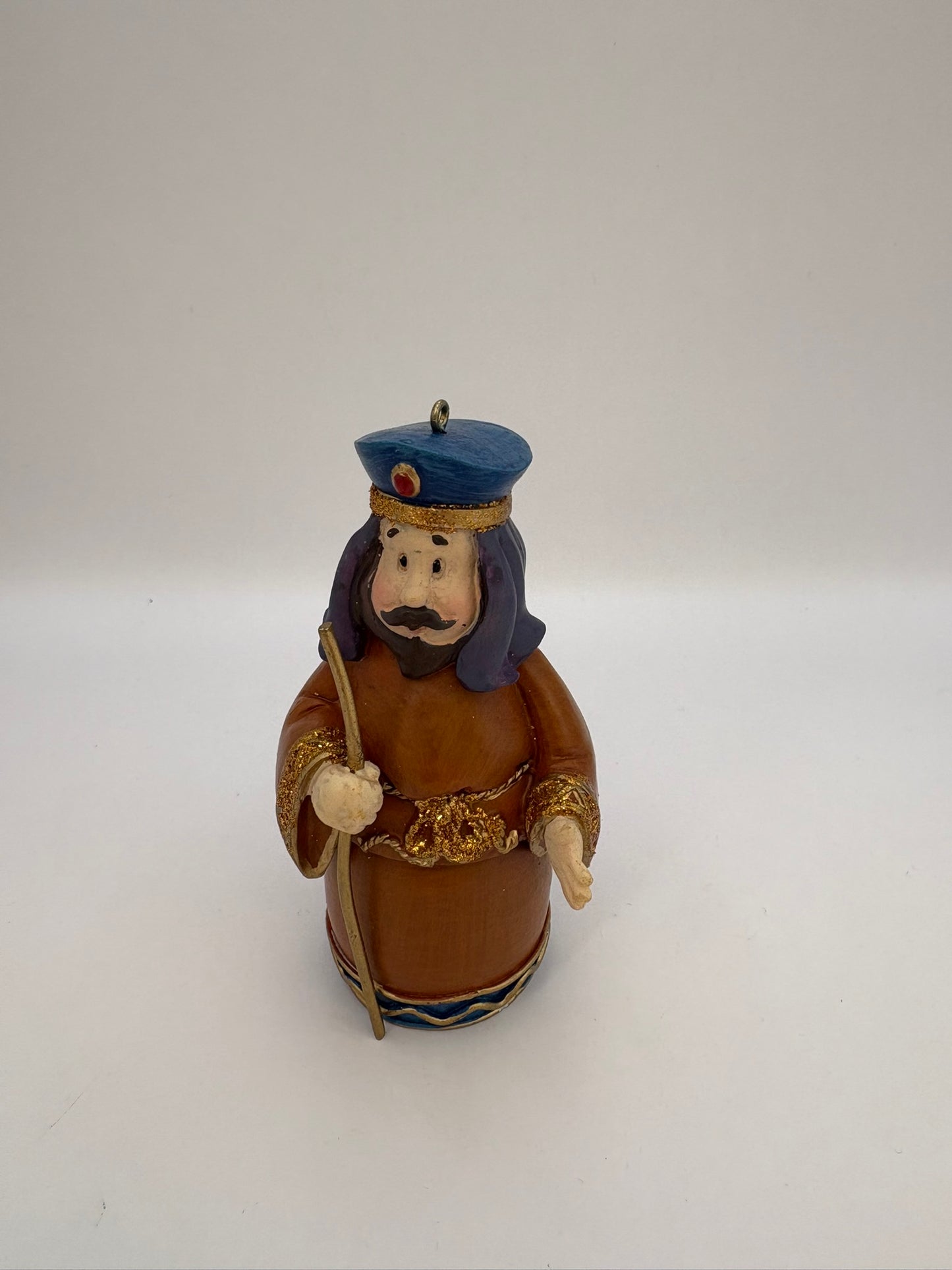 Decorative figurine of a character with a blue hat and brown outfit on a white background