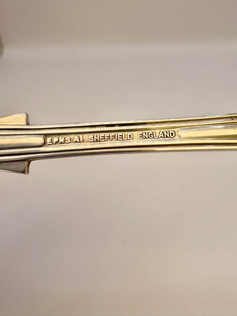 Gold object with 'Lonsdale Sheffield England' engraving on a light gray background