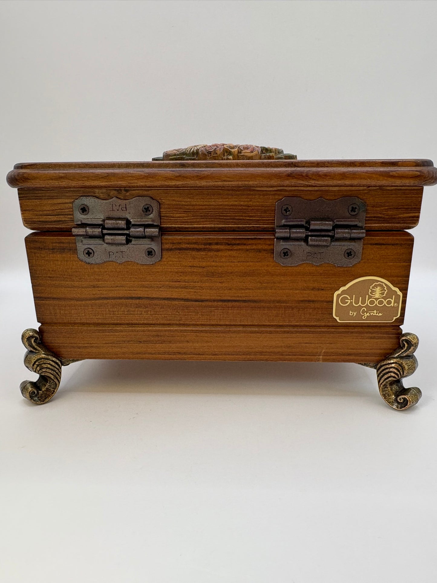 Wooden jewelry box with metal hinges and feet on a white background