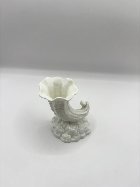 White ceramic vase with a unique design on a light gray background