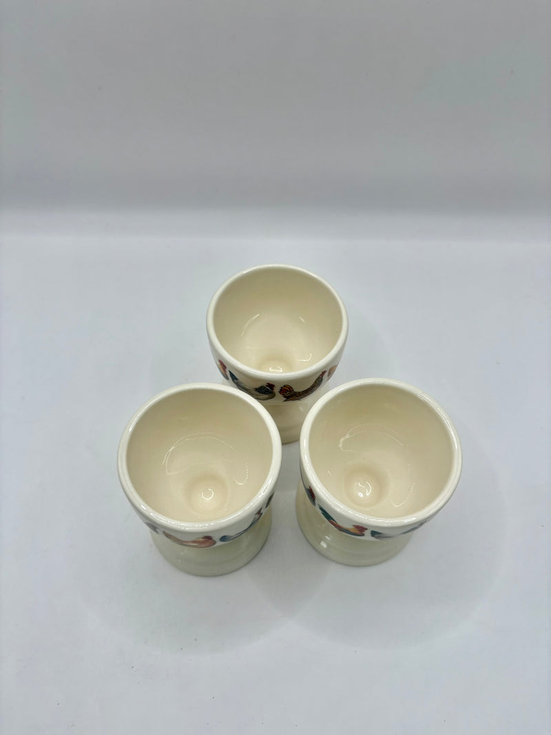 Three ceramic cups with floral patterns on a white background