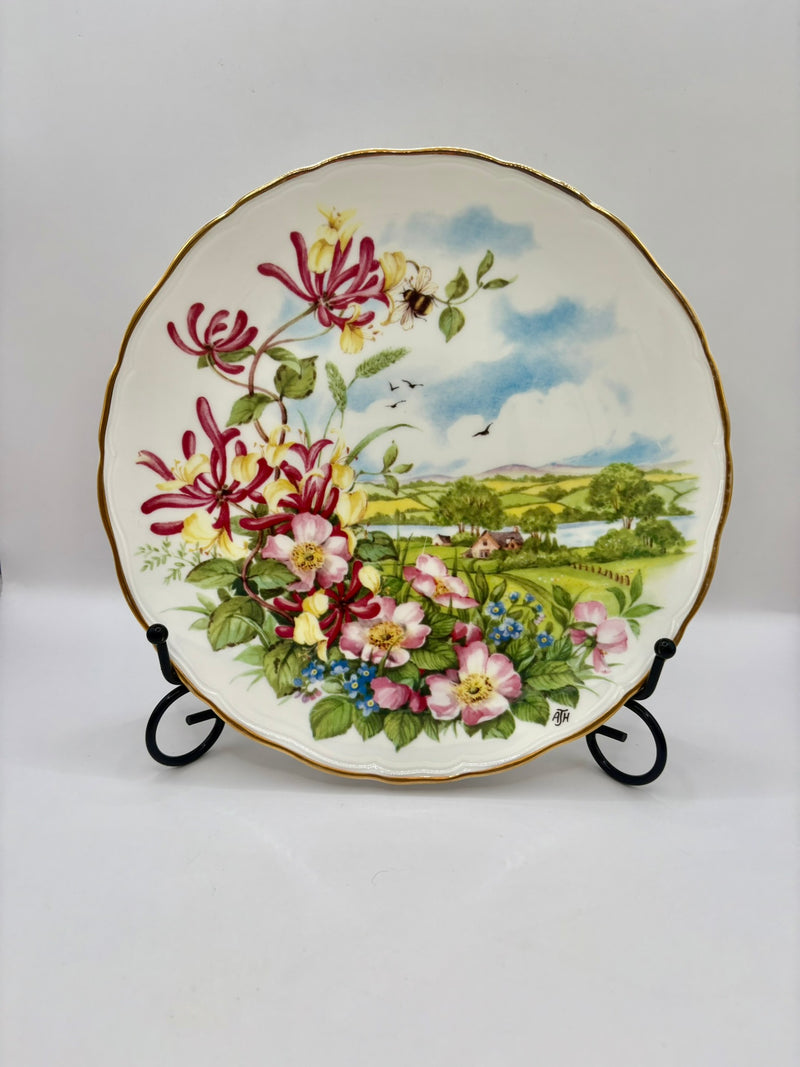 Decorative plate with floral design on a stand against a white background
