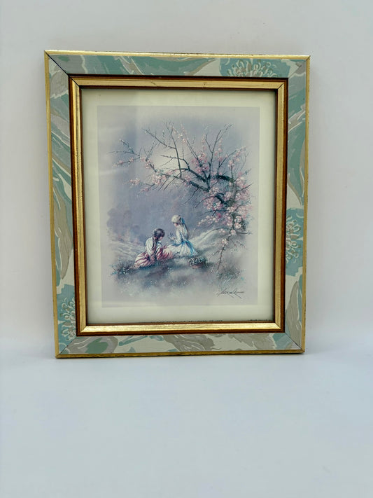 Framed artwork of two people under a cherry blossom tree on a white background