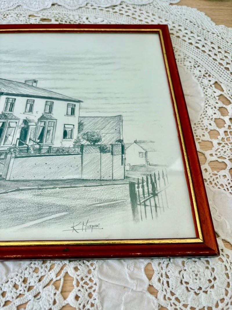 Framed pencil drawing of a house on a lace tablecloth