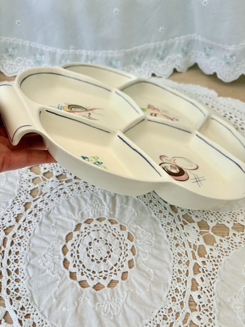 Decorative ceramic dish with cartoon characters on a lace tablecloth