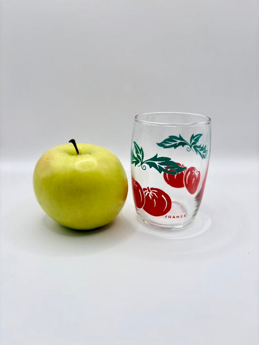 One glass shown against a white background and an apple aside it