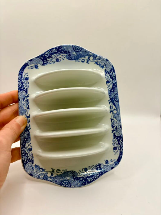 White plastic mold with blue floral design on a white background