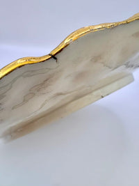 Marble-patterned object with gold edge on a white background
