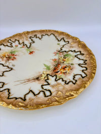 Decorative plate with floral design and gold trim on a white background
