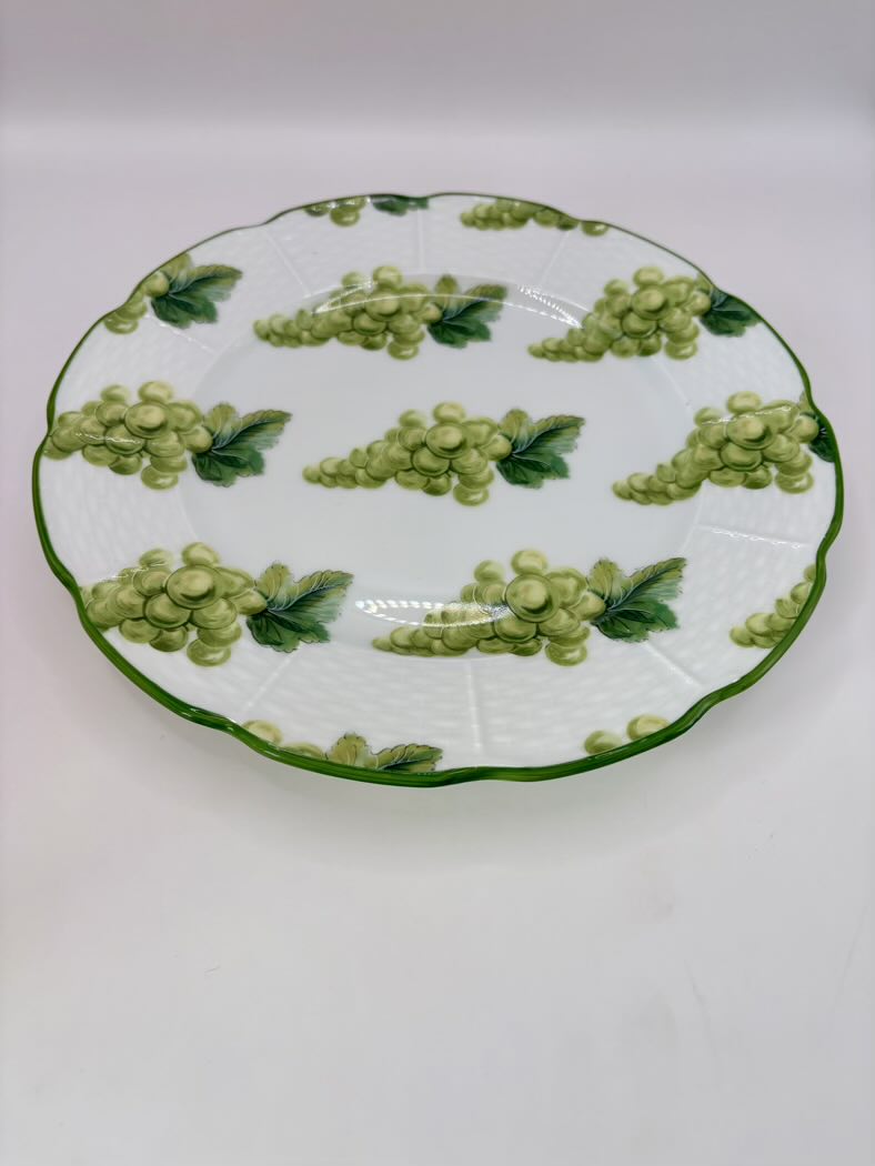 Decorative plate with green grape design on a white background