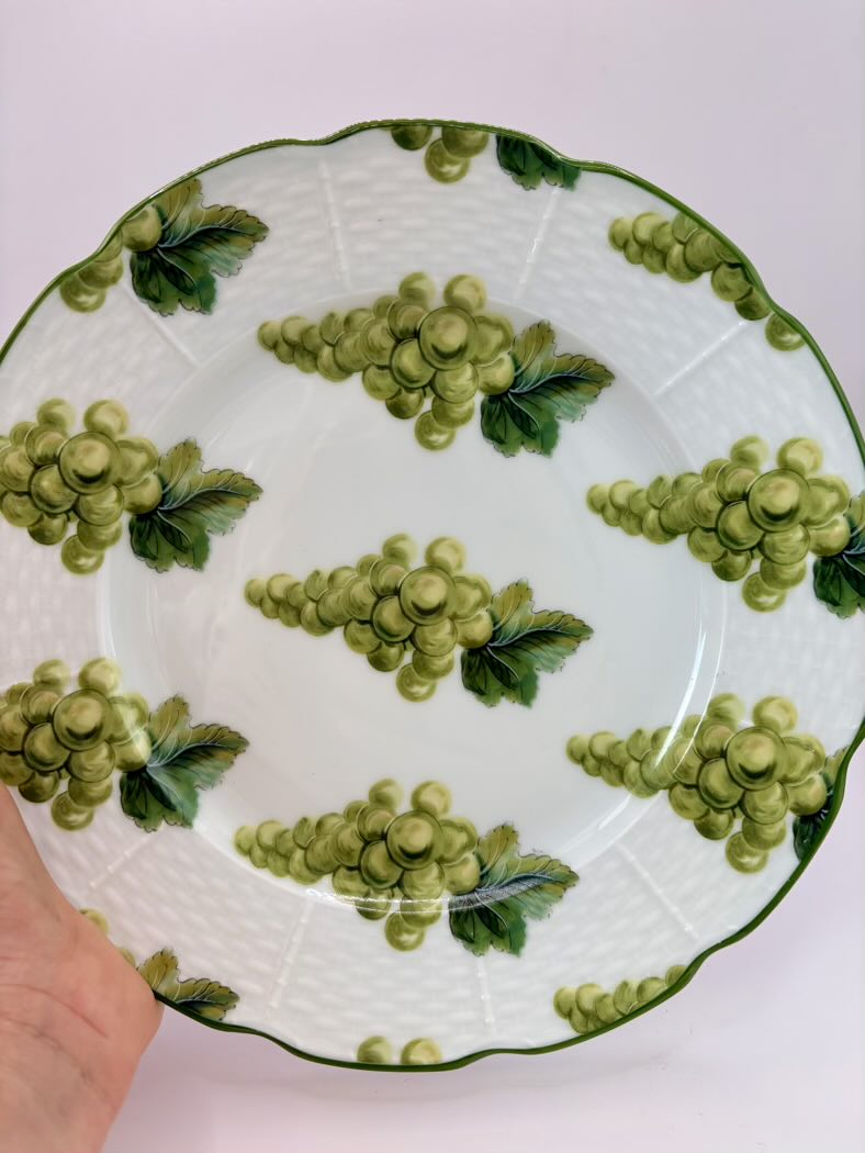 Ceramic plate with green grape design on a white background