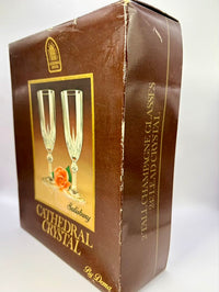 Box of Cathedral Crystal champagne glasses with a brown and gold design.