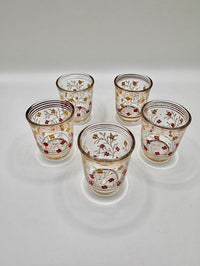 Set of five decorative glass tumblers with floral patterns on a white background