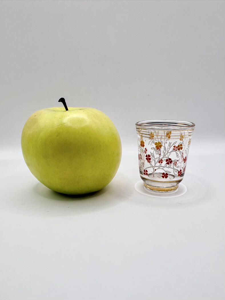 Green apple and decorative glass on a white background