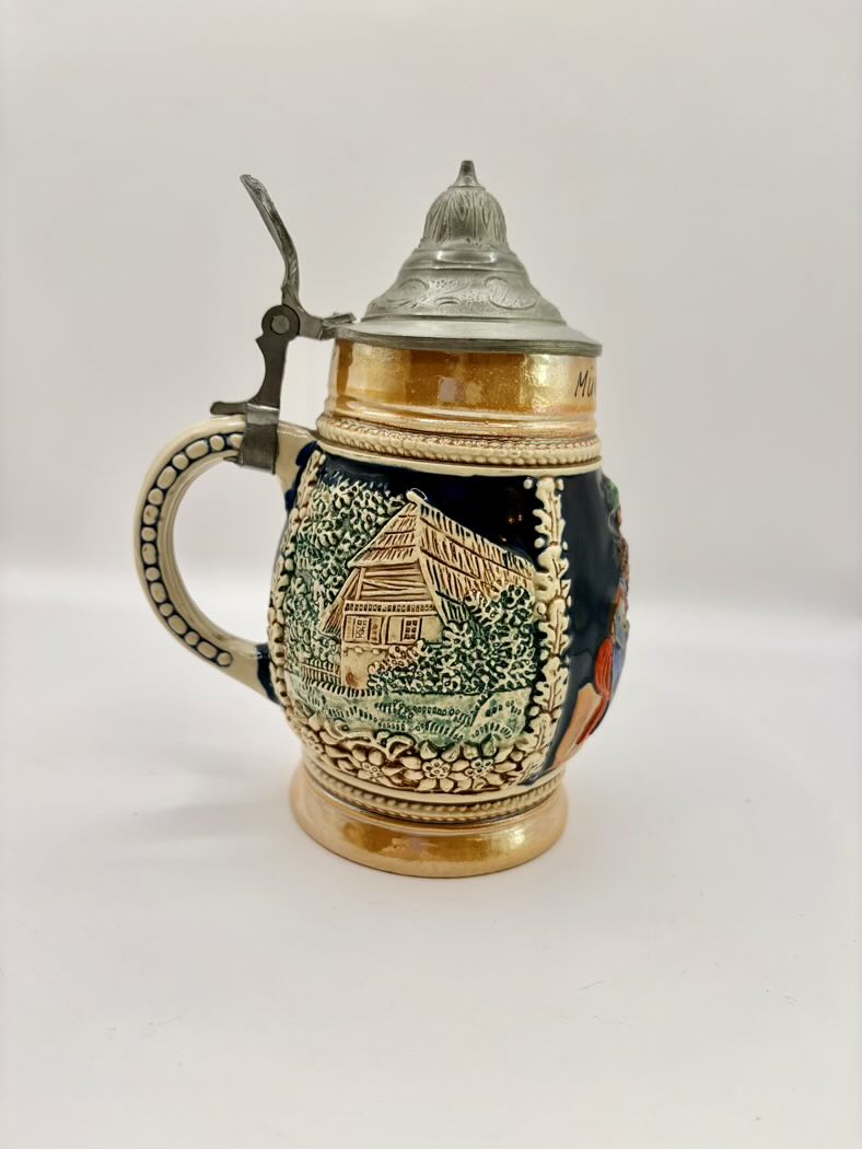 Decorative ceramic stein with lid on a white background