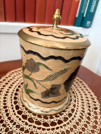 Decorative jar with floral patterns on a doily