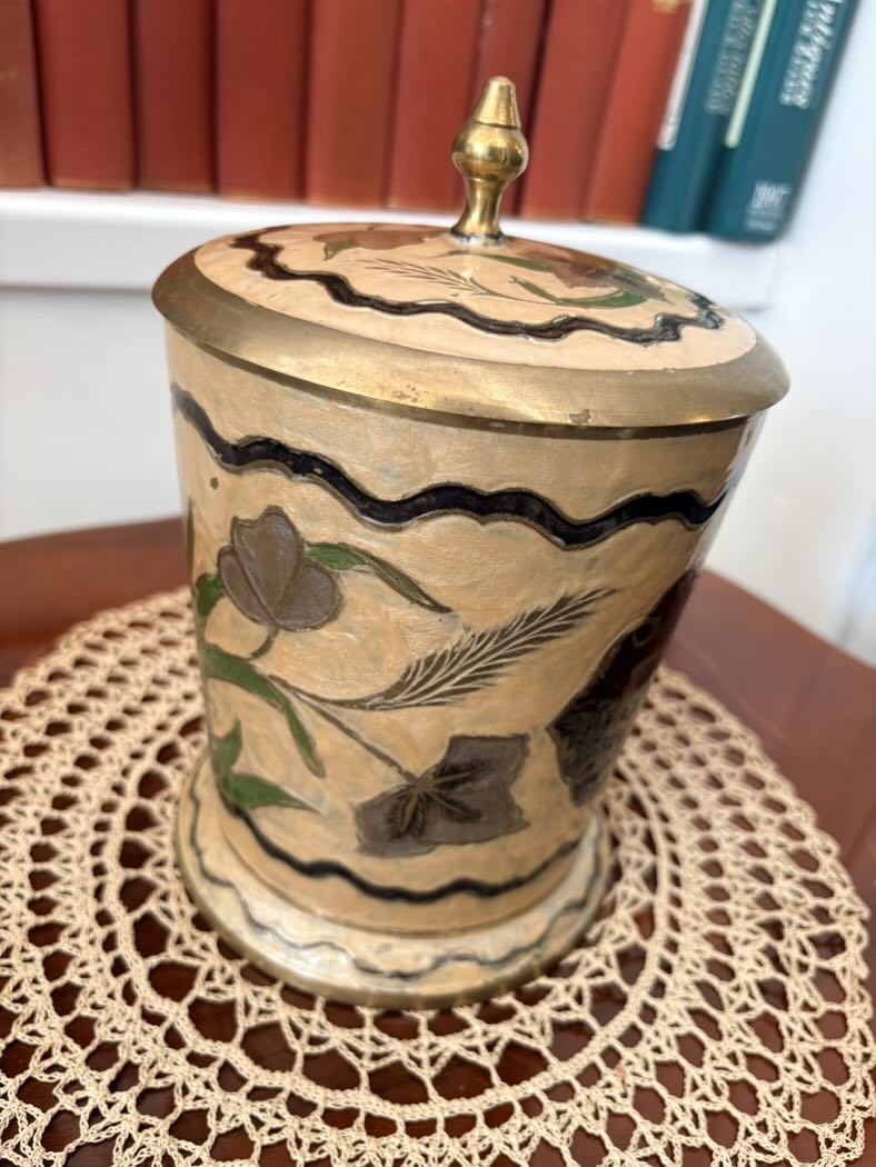 Decorative jar with floral patterns on a doily