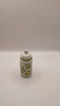 Decorative salt shaker with floral pattern on a white background