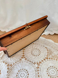 Wooden box with a gold clasp on a lace tablecloth
