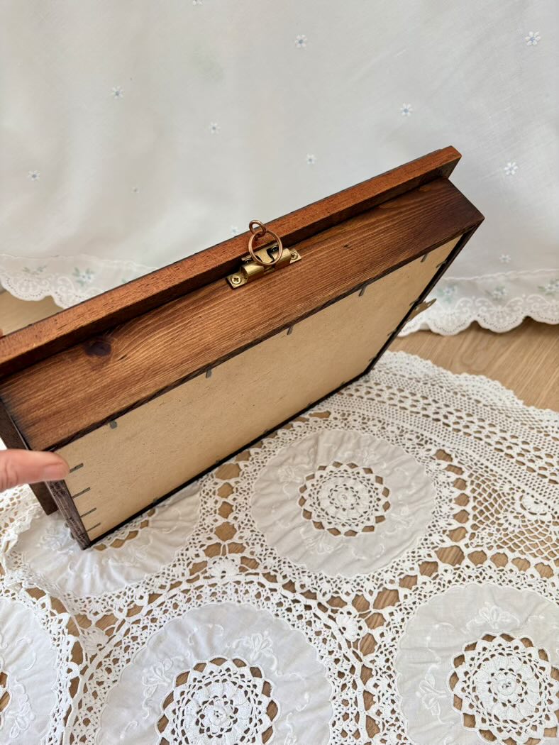 Wooden box with a gold clasp on a lace tablecloth