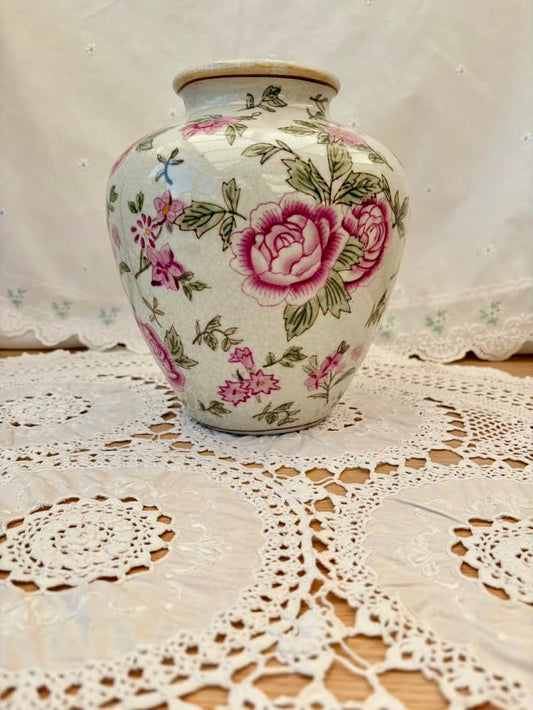 Decorative vase with floral patterns on a lace tablecloth
